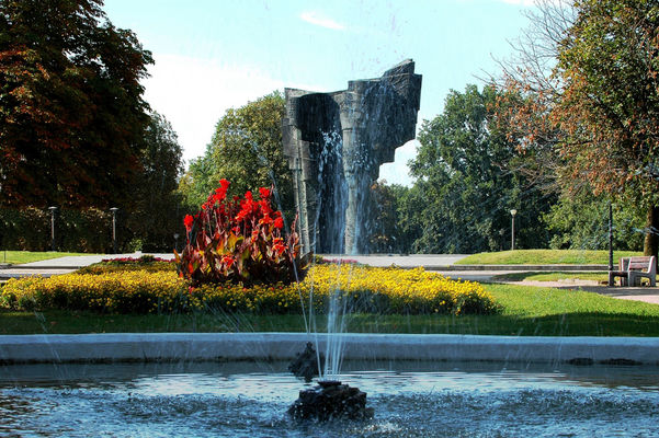Z Placu Obrońców Warszawy spojrzenie na pomnik Broniewskiego .
